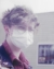 a profile image of an individual with short brown hair and a medical mask. 