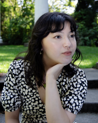 A young brunette woman, chin in hand