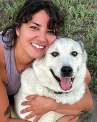 a girl hugging a white dog.