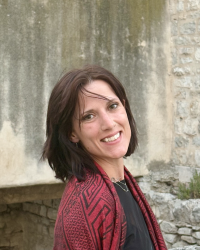 Hunter smiling, standing in front of stone wall