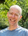 Charles LaPorte smiling under cherry trees on UW campus