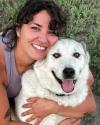 a girl hugging a white dog.