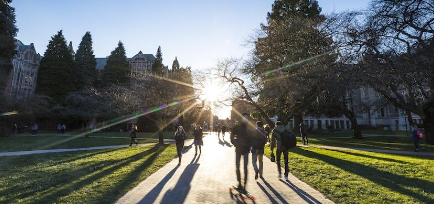 The quad with people walking in front of the sun.