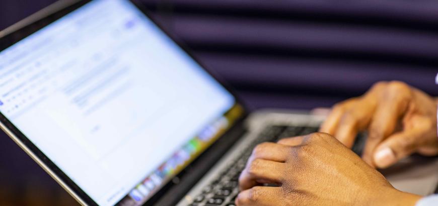 Hands typing on laptop keyboard